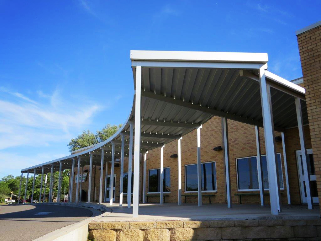 An aluminum canopy walkway is shown at an elementary school.