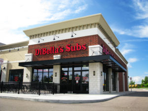 A sub restaurant is pictured with a black Mapes SuperShade canopy.