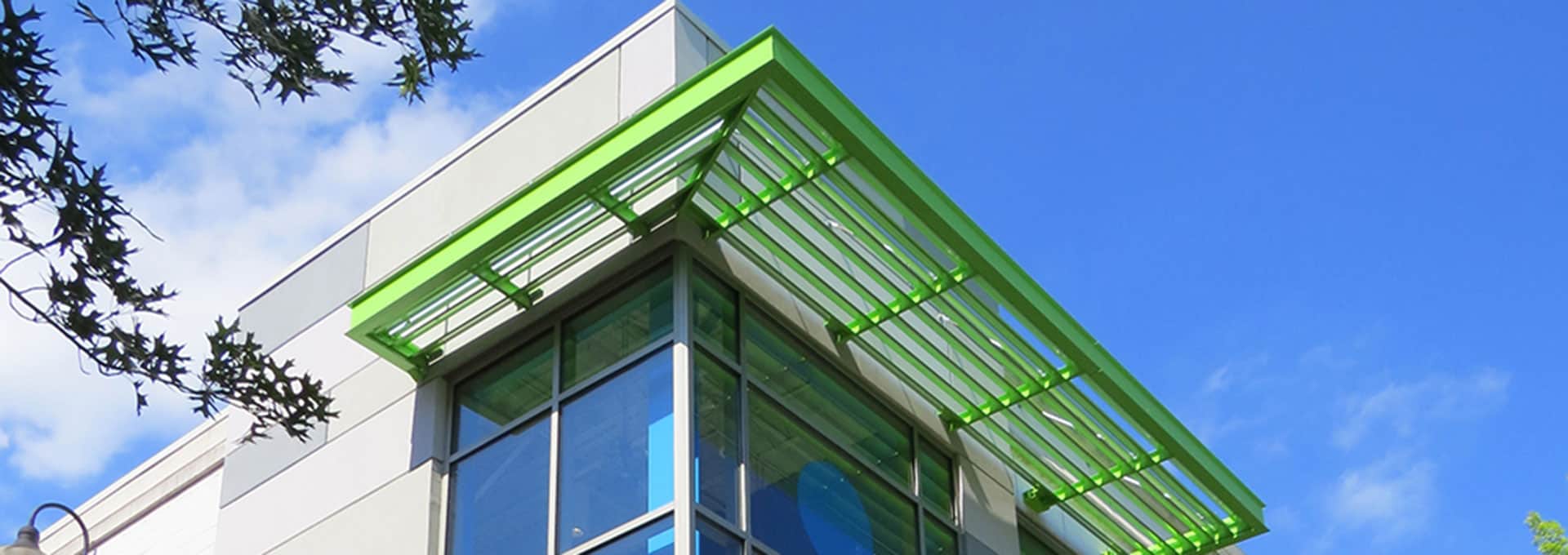 A green aluminum canopy on a commercial building is shown.