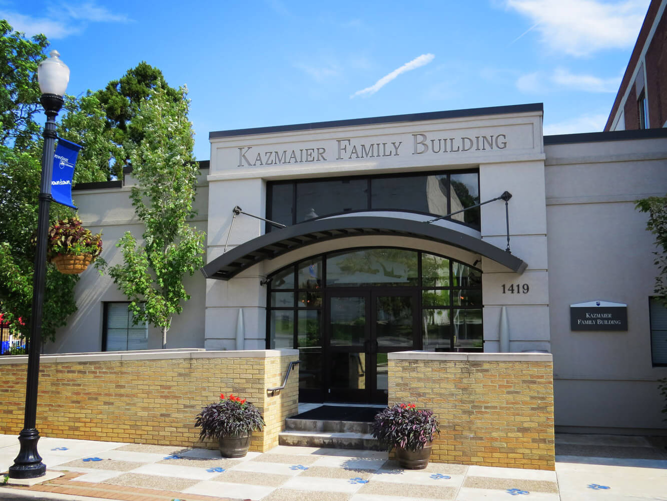 This image depicts a curved Mapes aluminum canopy being used in a commercial outdoor design.