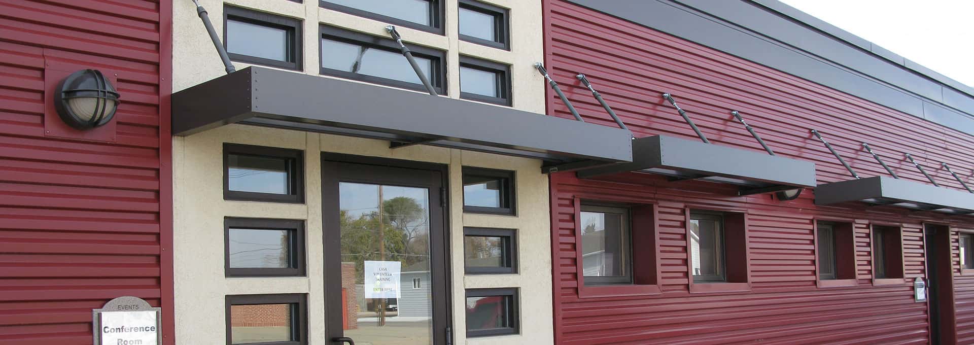 An aluminum canopy on a red building is shown.