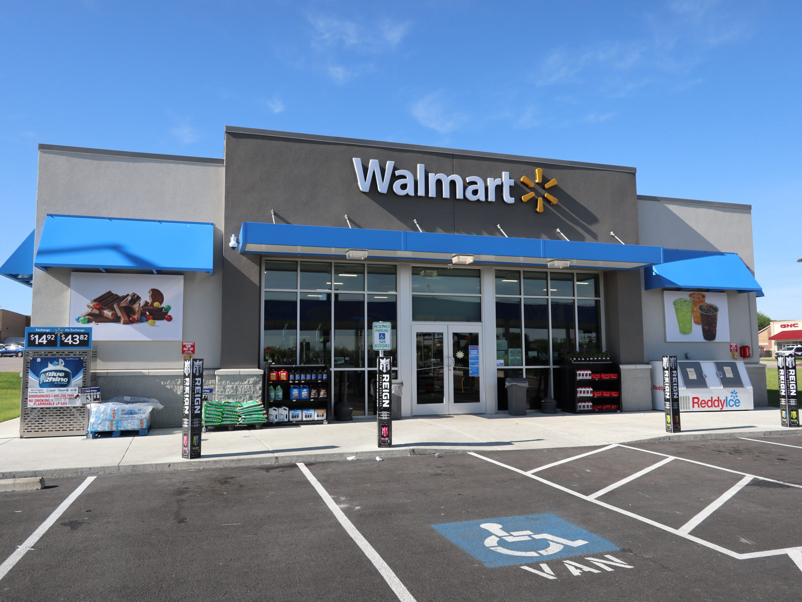 Exterior view of a Walmart store featuring a Mapes canopy, surrounded by a parking lot.