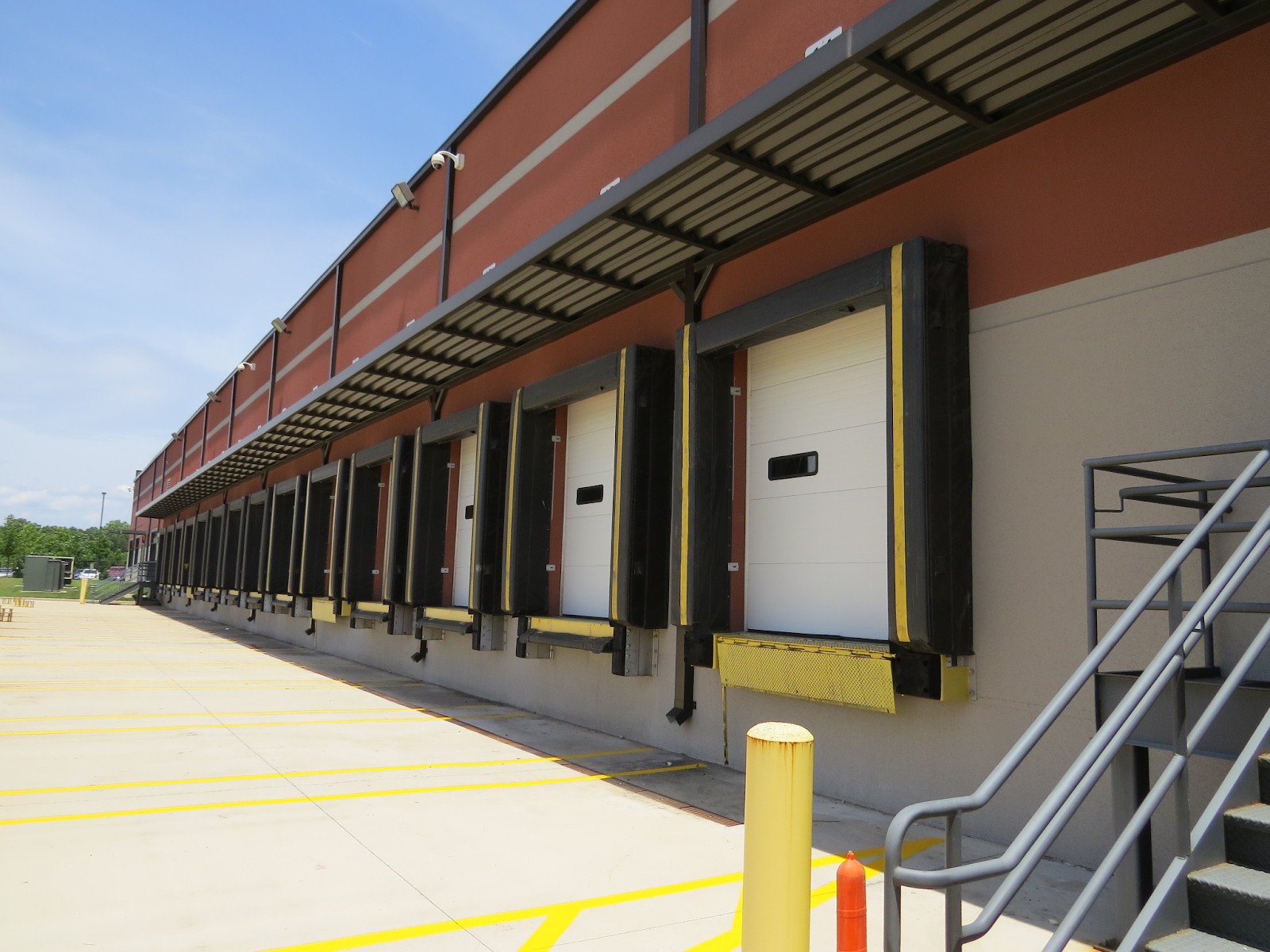 A long canopy covers a loading dock outside a commercial building.