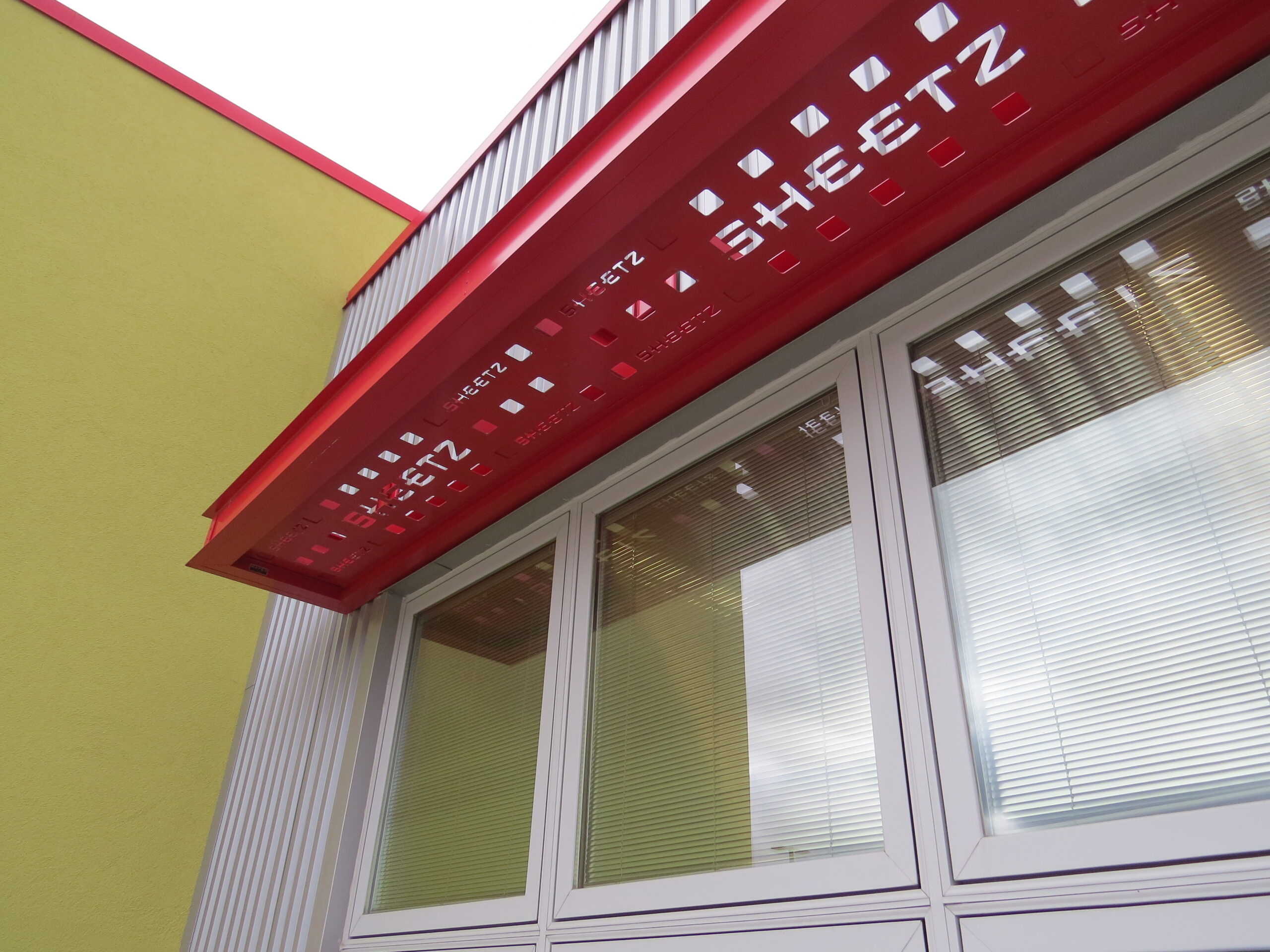 This image depicts a Sheetz canopy with classic red branding and a custom perforated deck to display their name. The canopy was made by Mapes. 